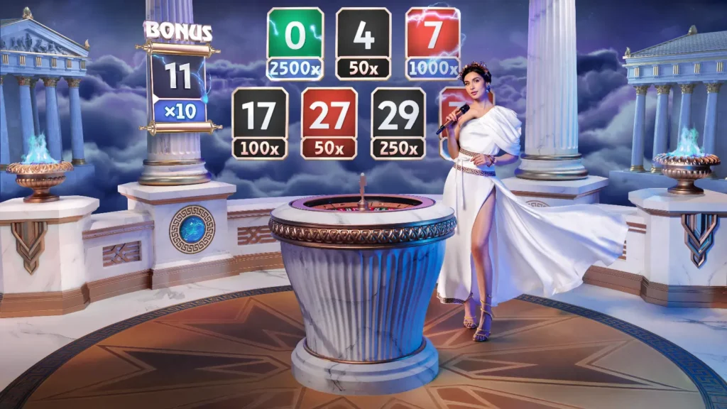 Live casino-vertinne kledd i antikk gresk kjortel presenterer bonusmultiplikatorer i Gates of Olympus Roulette, med gyldne symboler og spillbord i bakgrunnen.