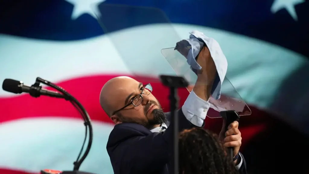 bilde av gabriel perez fra det hvite hus mens han rengjør teleprompter. bildet tatt under en tale for president trump i mars 2026